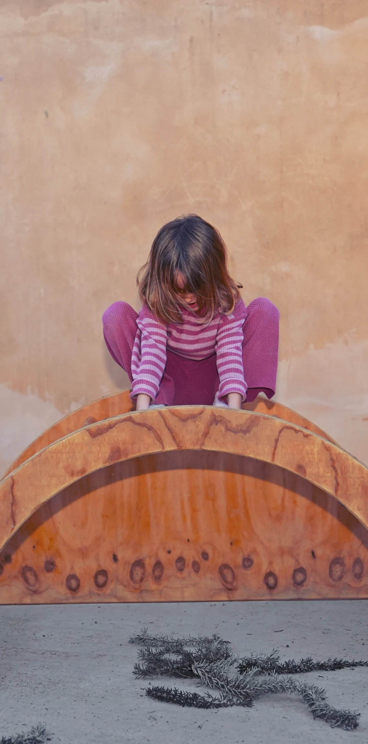 Niña sobre juguete de madera